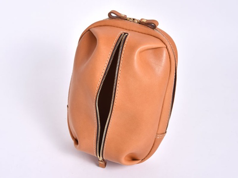 棕色皮革製成的立體運動斜背包，側面有一個拉鍊開口，頂部有拉鍊和皮革提把，縫線清晰。