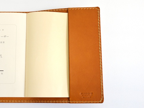 焦糖色皮革厚革書套，手工縫線，左側內頁有部分日文文字。