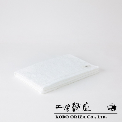 一張白色、摺疊整齊的今治超細纖維毛巾，材質柔軟，表面有細緻的絨毛紋理。