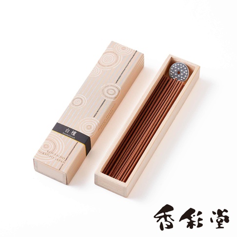 一盒淺米色紙盒裝有京都百樂香白檀香氛線香，盒蓋印有白色螺旋紋和銀色線條，黑色標籤寫有「白檀」字樣。打開的盒子裡是木質內襯，裝著約 20 支細長的棕色香氛線香，頂部有一個圓形金屬香座。