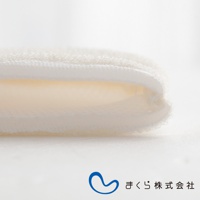 白色蠶絲洗臉手套，材質柔軟，邊緣有縫線，呈現輕柔的質感。