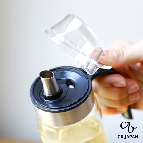 CB JAPAN 品牌 logo 旁為原子系列耐熱防回流玻璃油罐，罐身透明，裝有黃色液體，蓋子開啟，露出金屬壺嘴。