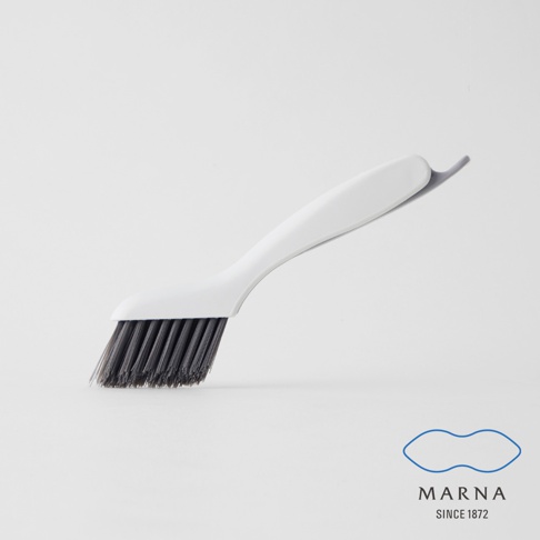 白色塑膠手柄縫隙清潔刷，帶有深灰色刷毛，刷頭角度傾斜，便於清潔狹窄縫隙。