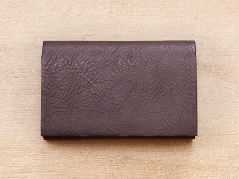 職人手作Organ薄型名片短夾 (GS-49)，深棕色皮革，表面帶有細緻紋理，置於淺色木紋背景上。