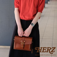 職人手作的經典混合風迷你單肩包，採用棕色皮革製成，配有黃銅色金屬扣環和可拆卸肩帶。