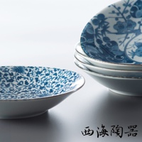 白色陶瓷淺盤，內側繪有藍色纏枝花卉與蓮花圖案。盤緣有細微的藍色線條裝飾，堆疊的盤子展示了不同的藍色植物和花鳥圖案。