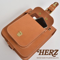 職人手作皮革立體口袋兩用單肩包，淺棕色皮革，配有黃銅扣環和縫線，包包上層有一個立體口袋，可放置手機。