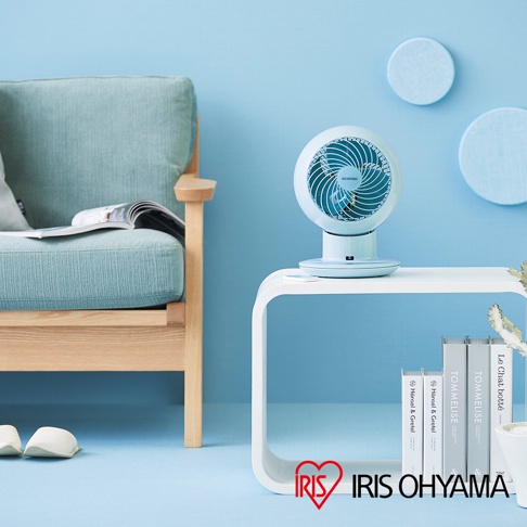 淺藍色IRIS OHYAMA PCF-SC15T 空氣循環扇，圓形扇頭，綠色扇葉，置於白色邊桌上，旁邊有書籍及植物。