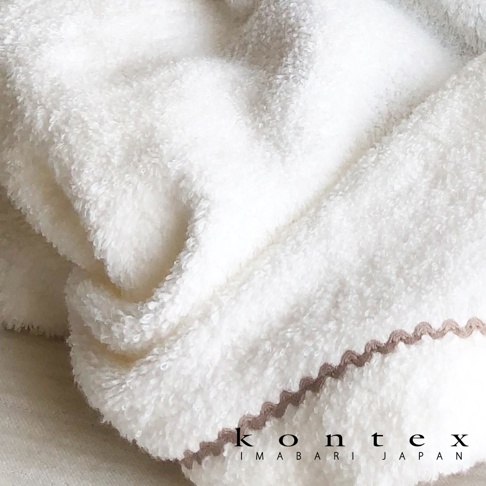 白色純棉連帽浴巾，質地柔軟蓬鬆，邊緣飾有淺棕色鋸齒狀滾邊，角落印有「kontex IMABARI JAPAN」字樣。