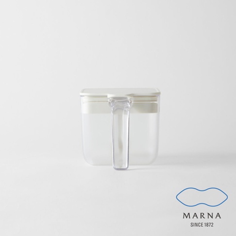 marna品牌的一款透明密封防潮調味料盒，主體由透明材質製成，配有白色蓋子與垂直把手，正對鏡頭的視角設計簡約，右下角印有藍色marna品牌標誌與創立年份。