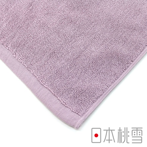 淺紫色毛巾，材質為柔軟的棉質，具有明顯的織紋和包邊細節。