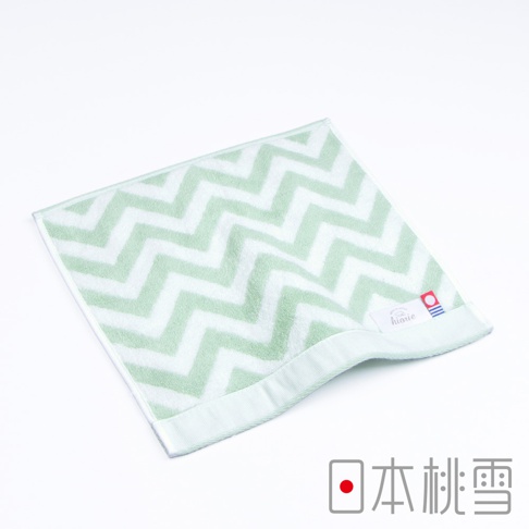 淺綠色與白色交織的鋸齒圖案方巾，材質柔軟，邊緣有細緻的車縫線，角落處有品牌標籤。