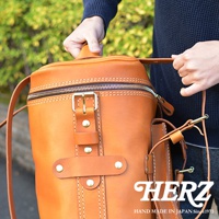 職人手作皮革大型三用旅行後背包，淺棕色皮革，銀色拉鍊與黃銅色扣環，縫線細緻，有側邊小袋，適合旅行攜帶。