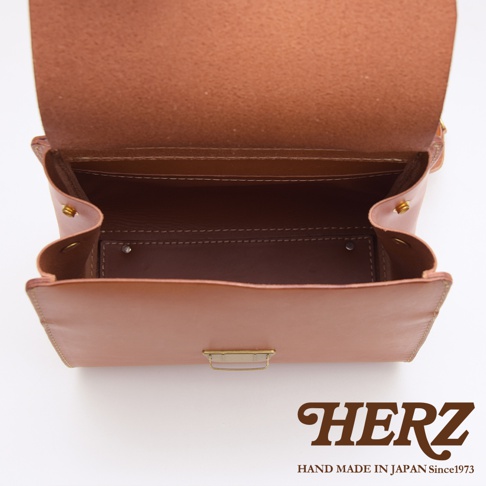 HERZ 職人手作皮革屋瓦風兩用單肩包，特寫展現精緻車縫線與品牌標誌，日本製造，質感皮革。