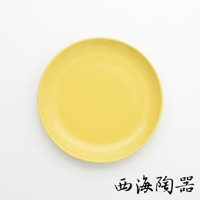 一個18公分的波佐見燒Common陶瓷料理盤，顏色為亮黃色，盤面平滑，邊緣有微微的弧度。