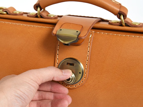 職人手作皮革橫長形單肩包，使用淺棕色皮革，配有復古黃銅色鎖扣和提把。