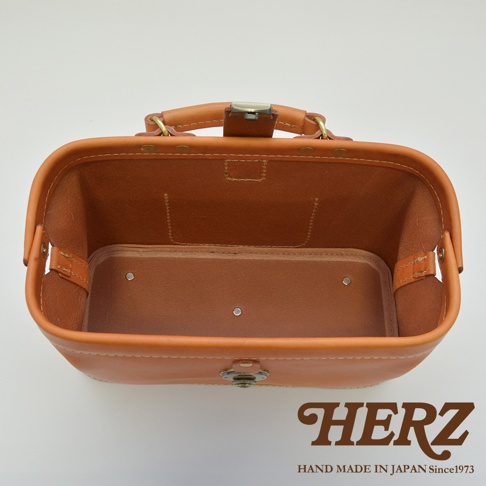 職人手作皮革長型迷你醫生包，呈現原色皮革，結構紮實，內有隔層，配有金屬鎖扣與提把。