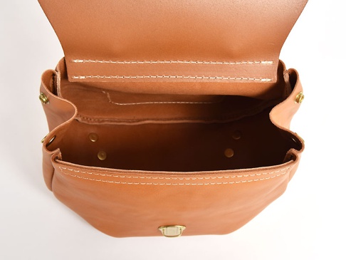 職人手作皮革屋瓦風迷你後背包 (R-6)，展示一個打開的棕褐色皮革迷你後背包，內部有兩排縫線，外部有黃銅鉚釘和扣環，整體呈現自然皮革質感。