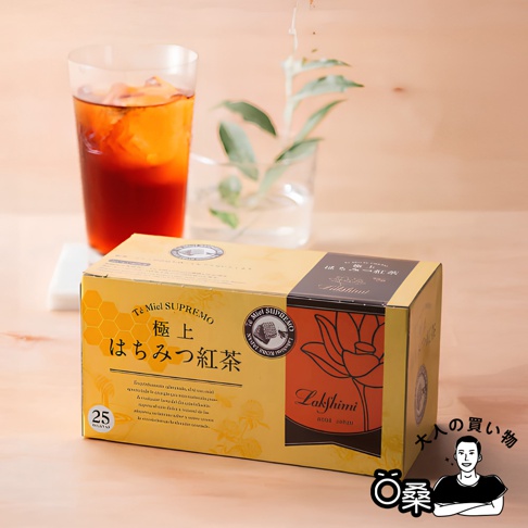 Lakshimi 極上蜂蜜紅茶禮盒，搭配一杯冰紅茶，背景為木紋桌面，展示精緻的茶飲產品。