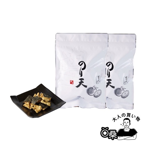 黑色方盤上盛放著海苔天婦羅餅乾，餅乾呈現金黃色，部分裹有深綠色海苔。背景為兩個白色夾鏈袋，上面印有黑色書法字體「のり天」及橘子圖案。