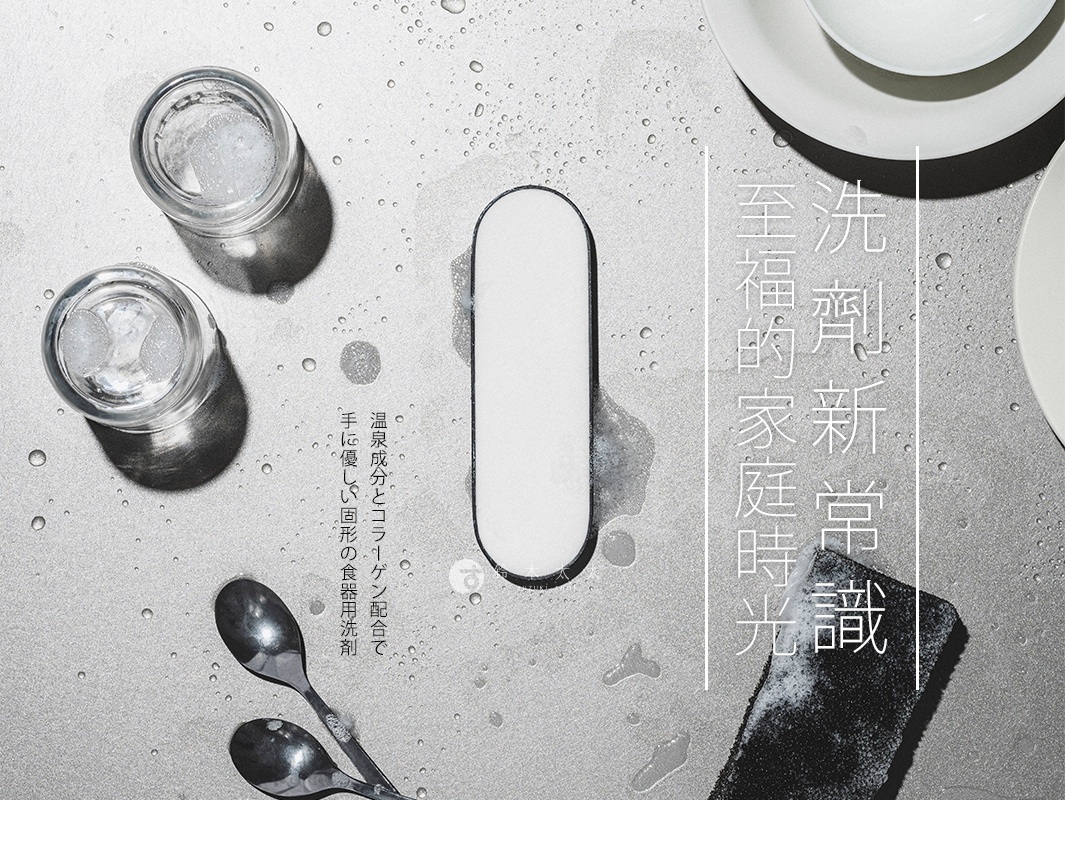 白色橢圓形固體皂置於潮濕的灰色檯面上，旁邊有兩個裝有冰塊和泡沫的玻璃杯、兩支銀色金屬湯匙以及一塊黑色海綿。