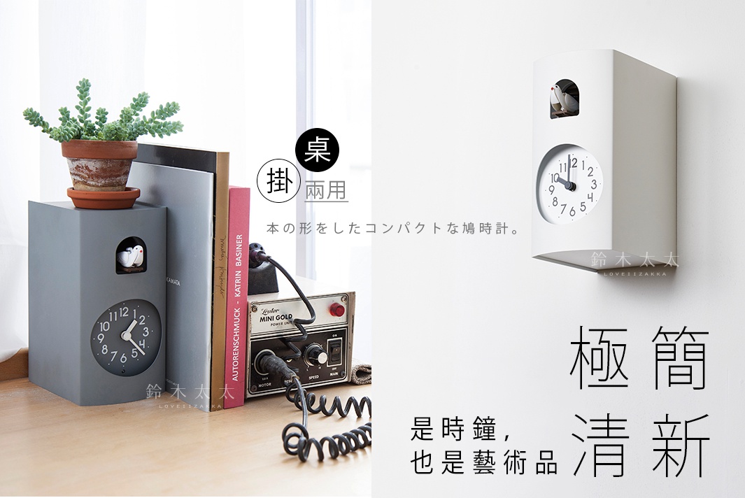 灰白色書本造型布穀鳥整點報時鐘，上方有小鳥裝飾，下方為圓形時鐘面，顯示時間，可掛牆或置於桌面。