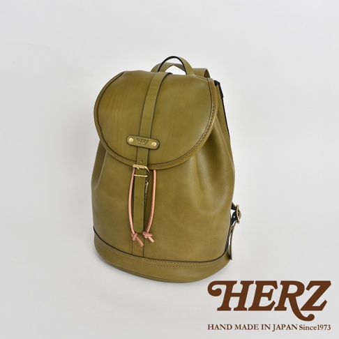 橄欖綠皮革單扣束口後背包，設有束帶、金屬扣環和品牌標誌。