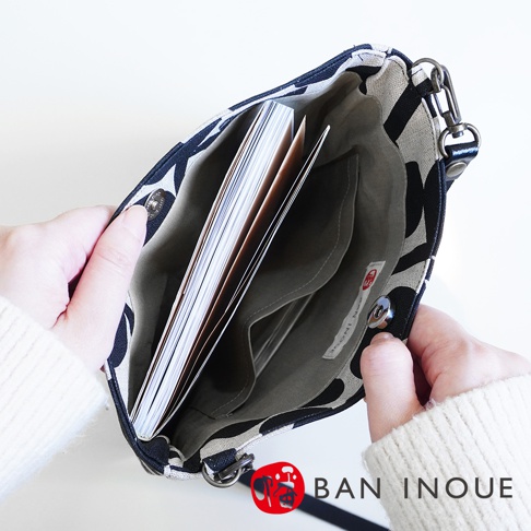BAN INOUE 果實花紋自然織紋麻布斜背包，內部有夾層，可放入書籍，由手持展示。