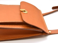 職人手作皮革厚實單肩包 (CP-61)，採用天然棕色皮革製成，帶有金色金屬旋釦。包身結構厚實，邊緣有精緻的白色縫線，展現細膩工藝。