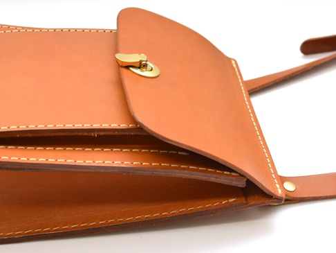 職人手作皮革厚實單肩包 (CP-61)，採用天然棕色皮革製成，帶有金色金屬旋釦。包身結構厚實，邊緣有精緻的白色縫線，展現細膩工藝。