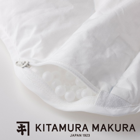 白色棉質枕套，拉鍊微開，露出內部的白色豌豆狀填充物。