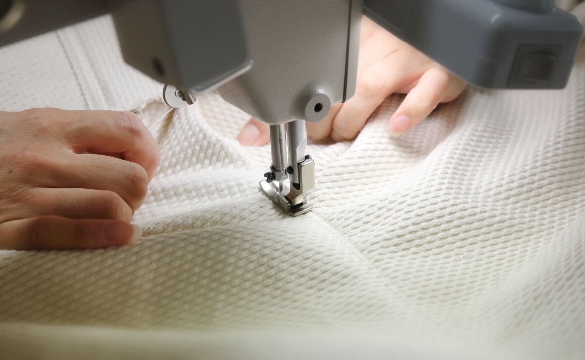 米白色三河木綿刺子織布料，以縫紉機縫製，展示布料的紋理與製作過程。