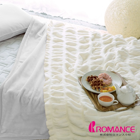 Aurora奶霜泡泡柔彈四季毯，奶油白色，採用獨特的泡泡紋理設計，觸感柔軟，適合全年使用。與白色枕頭和早餐盤一同展示。