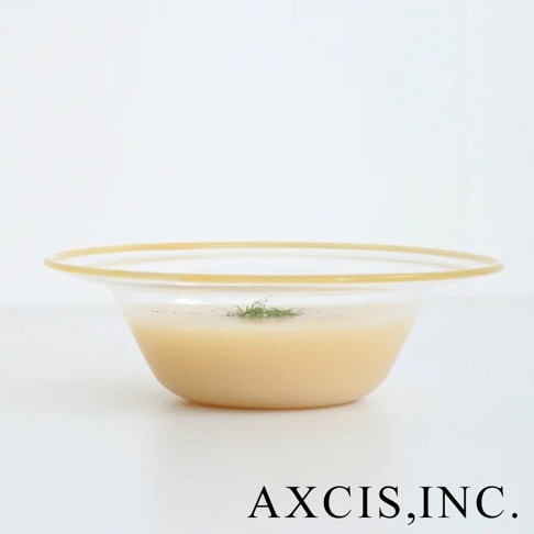 lykke 清透玻璃深型點心碗，帶有琥珀色滾邊，碗內盛有淺黃色湯品，上方點綴少許綠色香草。