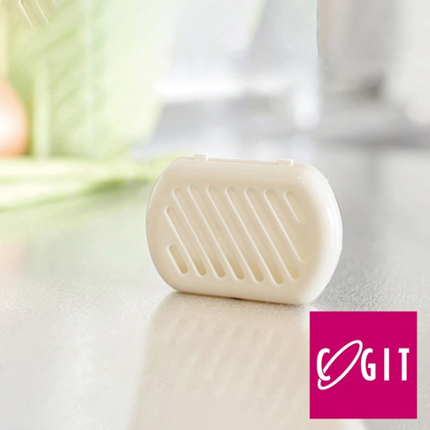 日製長效除臭防霉貼片盒，白色橢圓形塑膠盒，盒蓋有斜線通風孔，底部平坦，置於白色桌面，背景模糊。