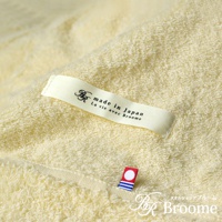 淺黃色今治毛巾被，觸感柔軟，帶有「made in Japan」標籤及小巧的日本國旗裝飾。