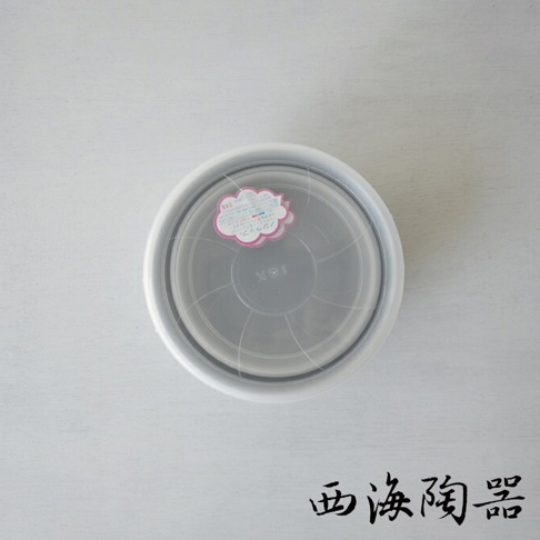 白色陶瓷外框，透明塑膠蓋，蓋上有粉紅色雲朵狀貼紙，中央印有日文及英文字母。
