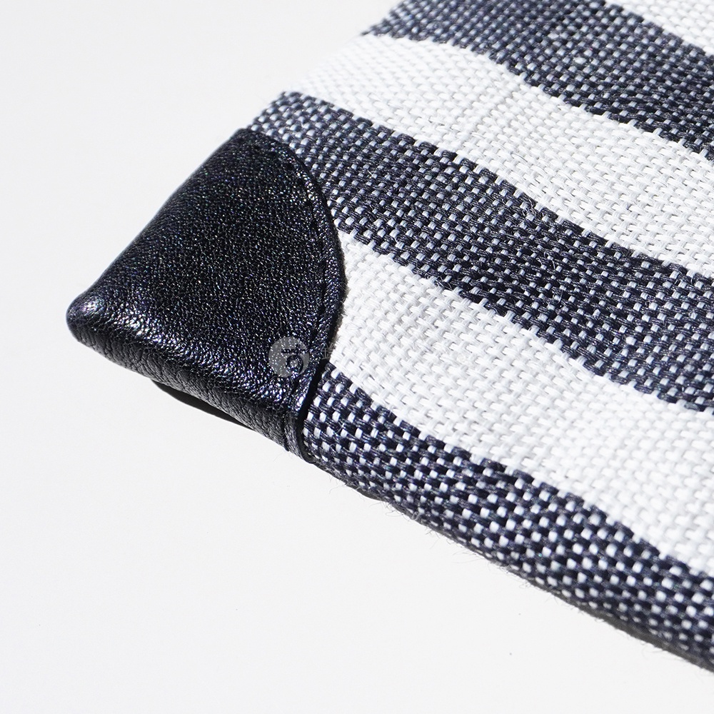 斑馬條紋麻布斜背包的黑色皮革尖端細節