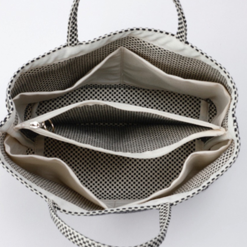 三河木綿刺子織多口袋托特包，以黑白格紋圖案呈現，內部設計有分隔的隔層和拉鍊口袋，展現其多功能收納結構。