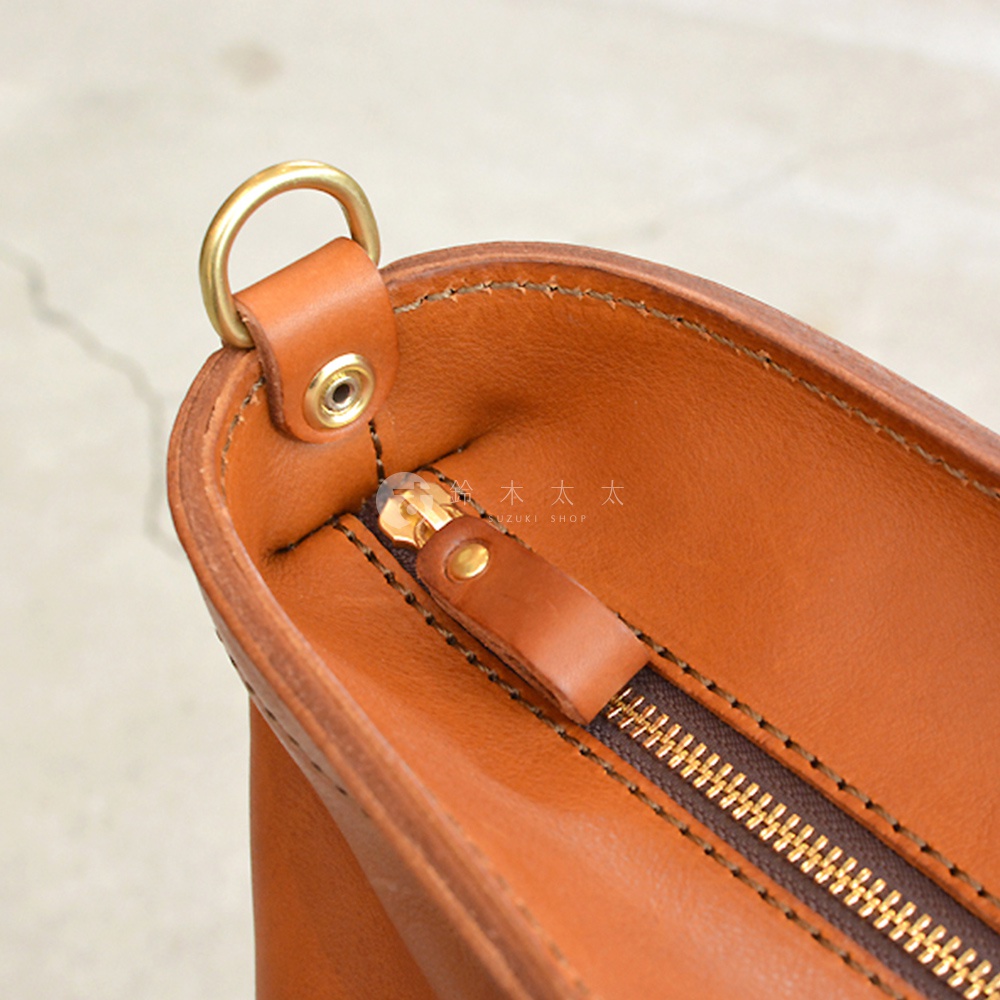 日本HERZ職人手作皮革Organ兩用拉鍊托特包 G-45 的細節，展示了包款的棕色皮革材質、金色拉鍊以及金屬D型環。