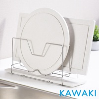 金屬架上置放兩個淺色珪藻土鍋蓋和砧板，左邊為圓形鍋蓋，右邊為方形砧板，架子下方為淺色珪藻土底座，整體呈簡約風格。