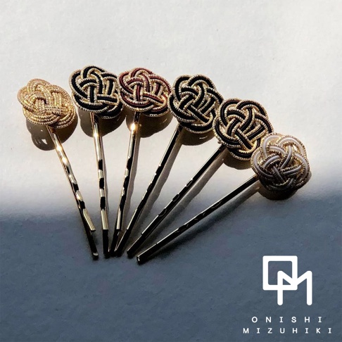 金絲線編織成的日式水引花結髮夾，共展現金色、黑金、紅黑、白金四種配色，髮夾為金色金屬材質。