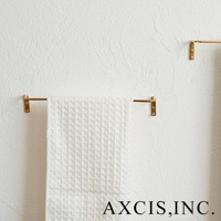 黃銅單桿毛巾架，設有兩組固定於白色紋理牆面上的小巧黃銅支架，其中一組掛著一條白色格紋毛巾。