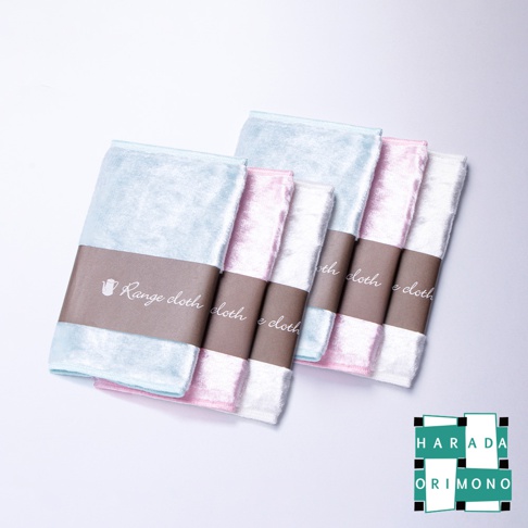 淺藍色、粉紅色和白色共六條絨面布，每三條為一組，用深褐色紙帶包裹，紙帶上印有白色文字和茶壺圖案。