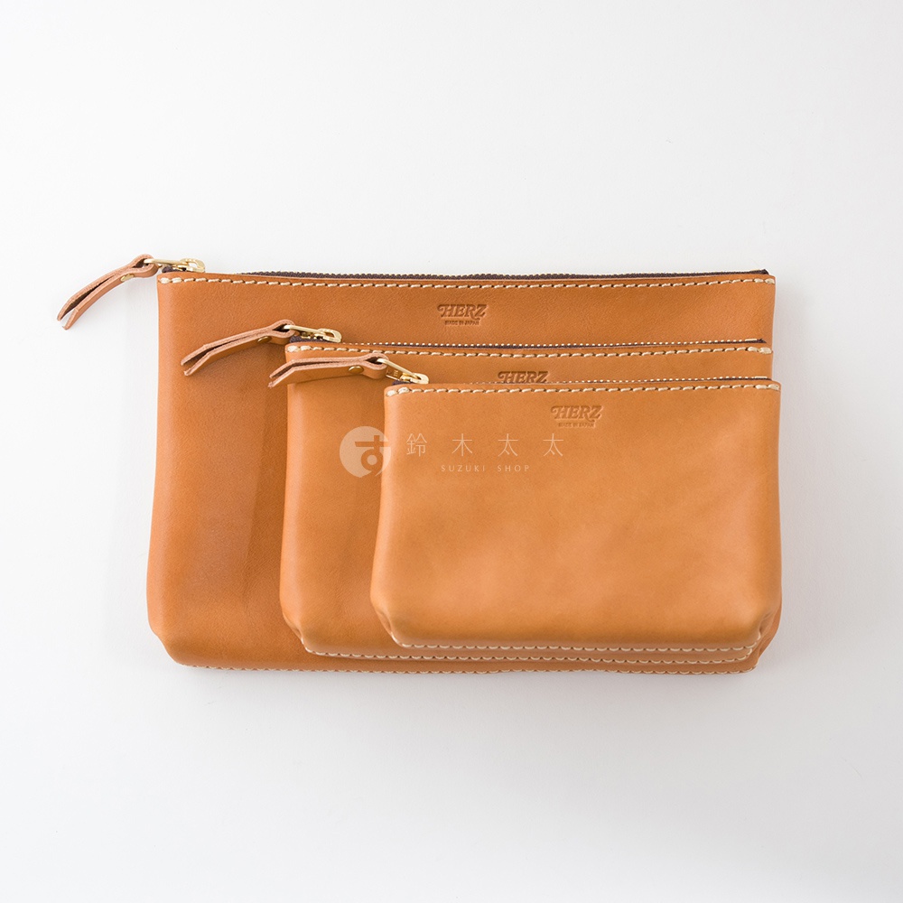 職人手作皮革長方形拉鍊收納包，共三種尺寸，皆為淺棕色皮革材質，配有拉鍊和皮革拉環，車縫線清晰。
