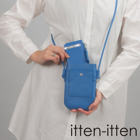 itten-itten 品牌 BOLLA 義大利皮革散步手機包，藍色皮革材質，左手正在將卡夾放入包中，包身有圓形金屬釦裝飾