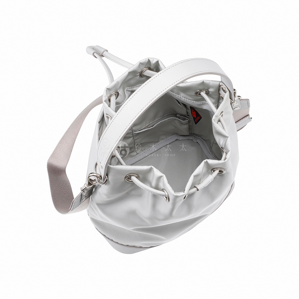 TUTUMU sacca Rich 兩用抽繩水桶包，白色皮革提把和肩帶，搭配銀灰色尼龍材質水桶包身，抽繩設計，內有小口袋，包口處有品牌標誌。