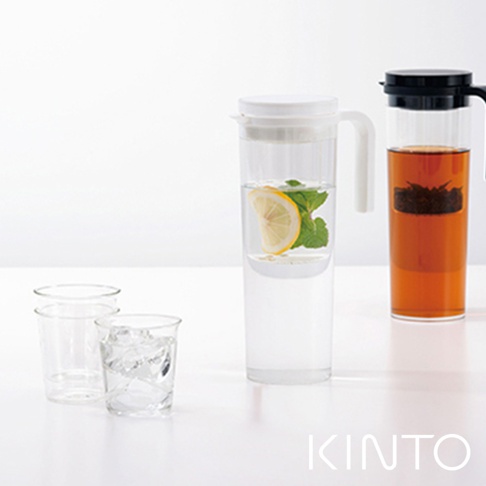 透明塑膠冷泡壺，壺內有檸檬片和薄荷葉，壺蓋白色。旁邊有一個裝有紅茶的透明玻璃壺，壺蓋黑色，以及兩個裝有冰塊的透明玻璃杯。