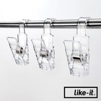 三個透明壓克力掛式小物夾，具有金屬彈簧，夾子開口朝下，掛在金屬桿上。
