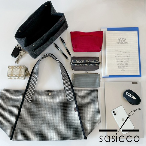 黑白格紋刺子織可變形托特包，搭配灰色內袋、鑰匙、筆、粉紅色化妝包、灰色零錢包、文件夾、筆記型電腦、滑鼠及手機。